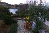 Side terrace with table and chairs and the bay beyond - Beach house/villa, Patmos, Greece